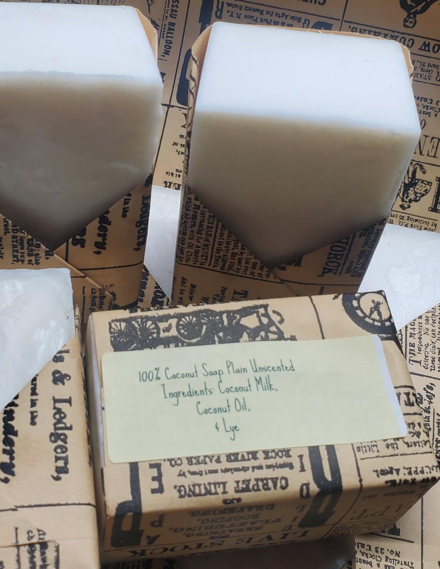 Close-up of plain unscented coconut soap bars wrapped in eco-friendly vintage-style paper, showcasing natural ingredients.