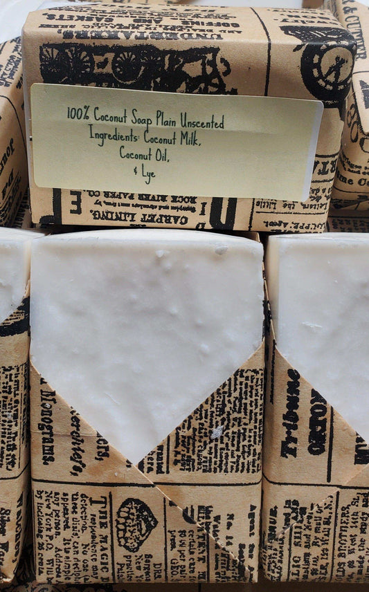 Plain unscented coconut soap bars wrapped in vintage-style paper with labeled ingredients including coconut milk, coconut oil, and lye.