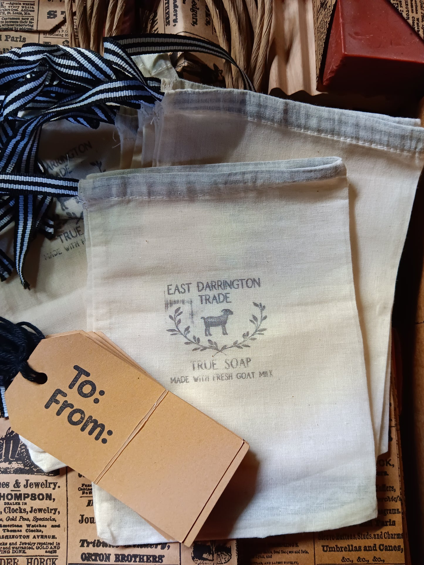 Bags snd tags with East Darrington Trade' branding, with striped ribbon and a gift tag on vintage newsprint bags.  Wholesale Order only 