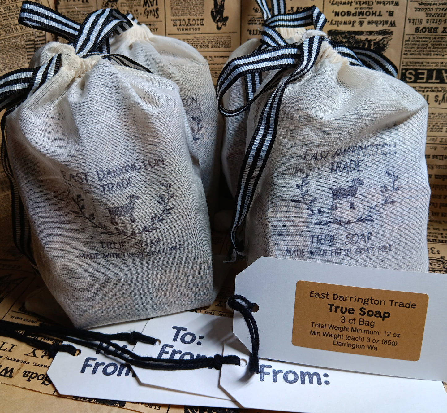 Four bags of East Darrington Trade True Soap on a newspaper background with a tags.