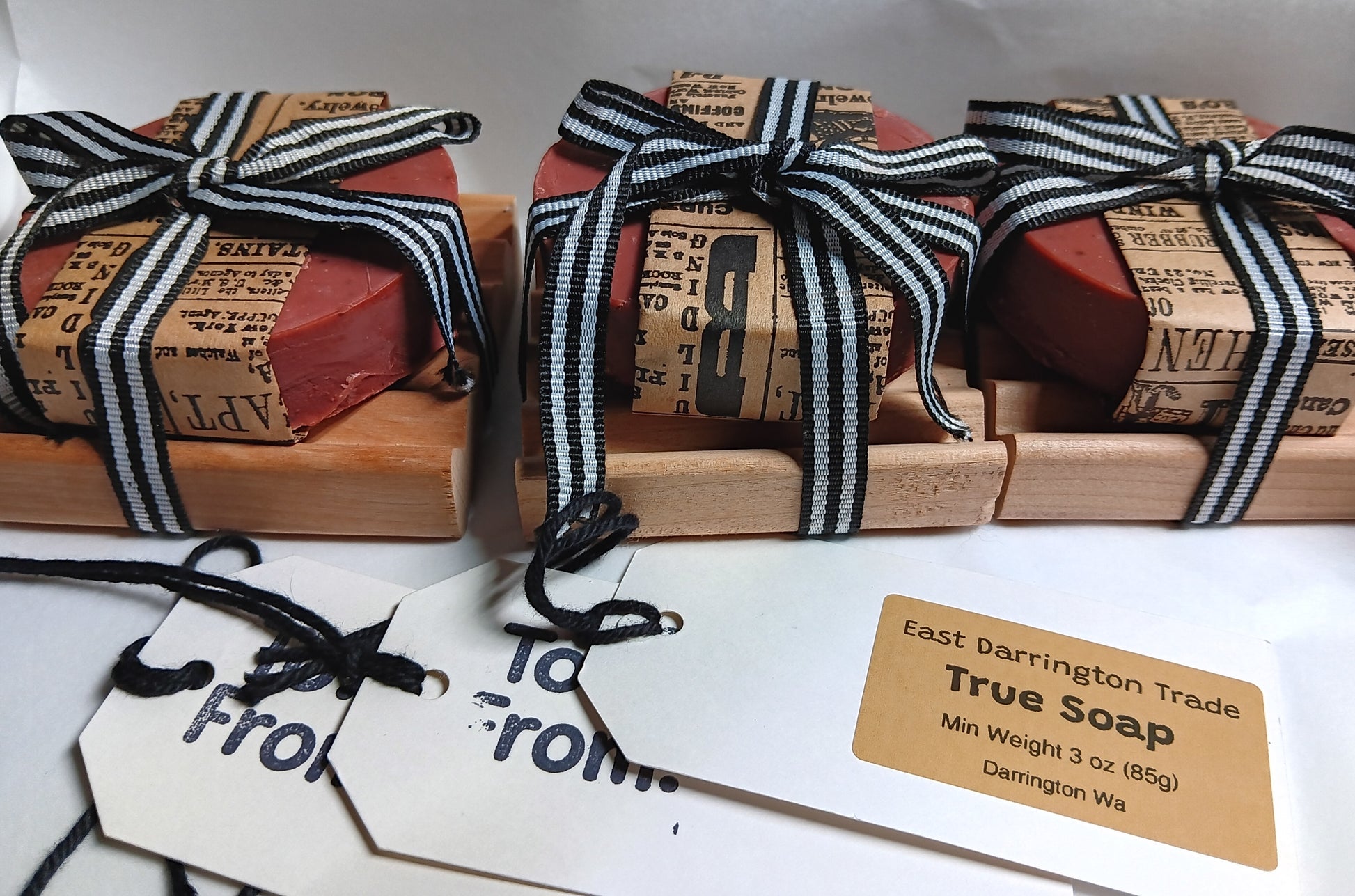 Three bars of soap wrapped in black and white striped ribbons with gift tags. COLD-PROCESS Goat Milk Soap Wholesale Minimum order $100.