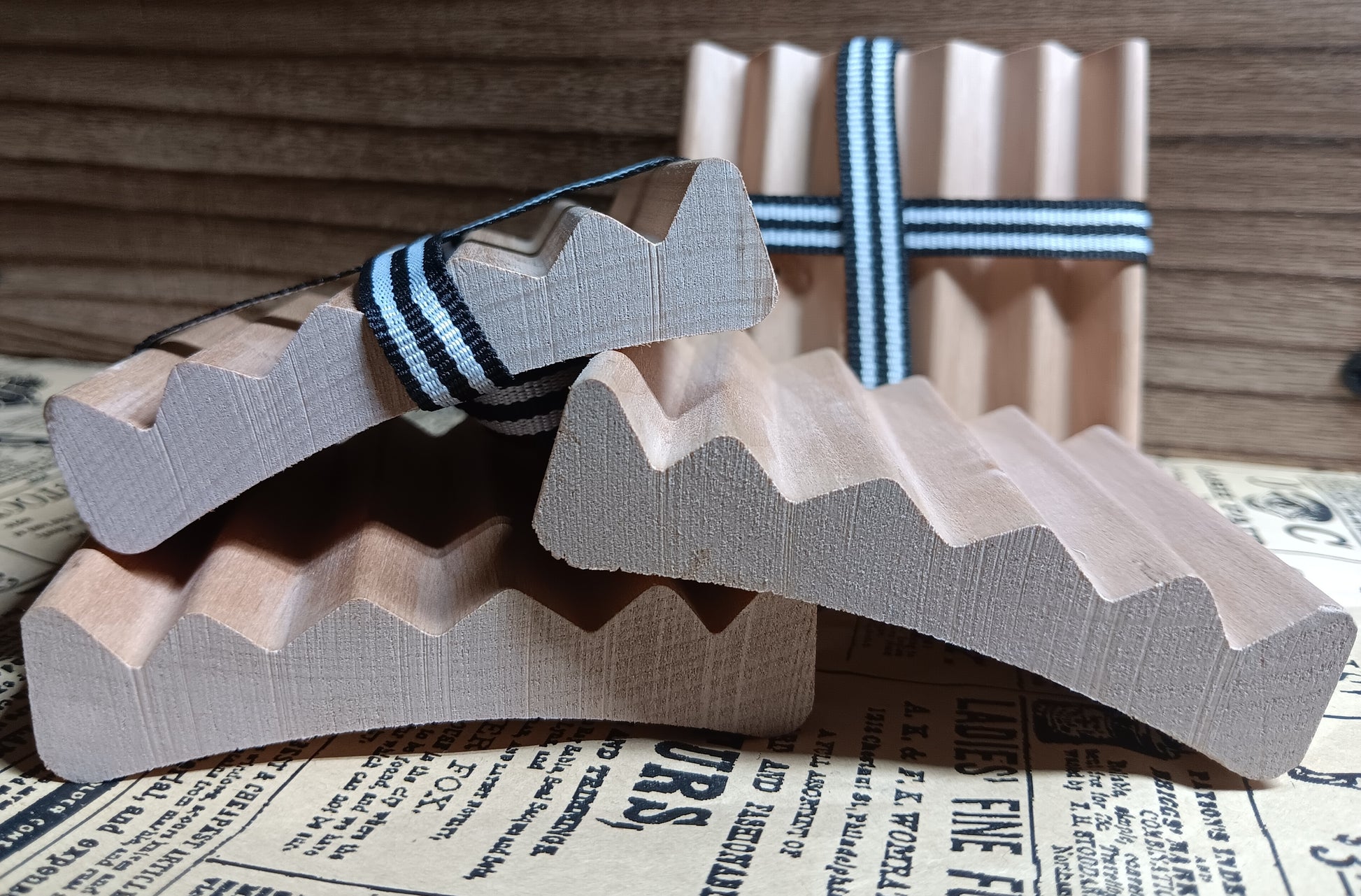 Wooden red alder soap dish with striped band on a newspaper background