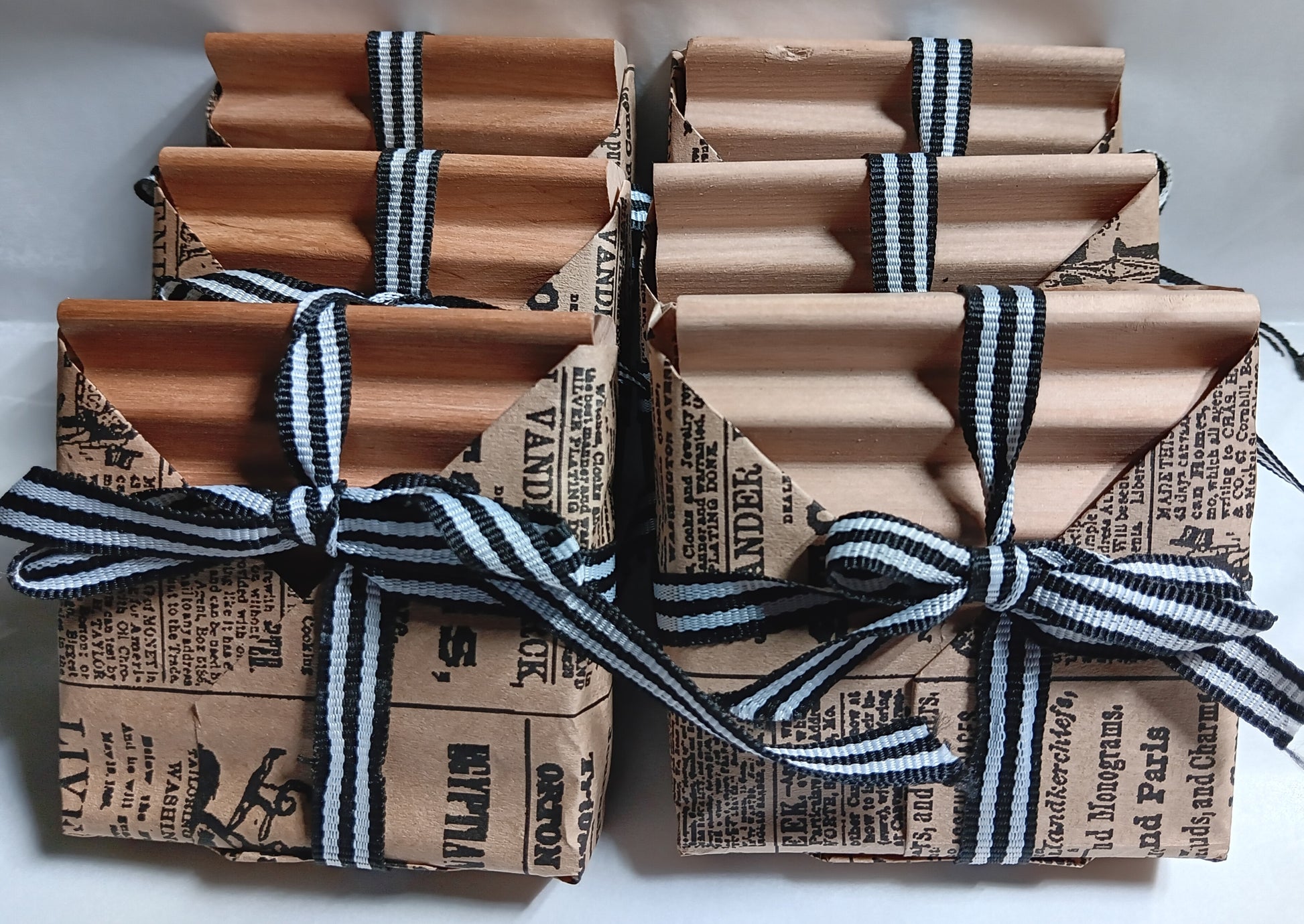 Wrapped Soap dishes with brown paper and black and white striped ribbons on a light background. 6 count wholesale case